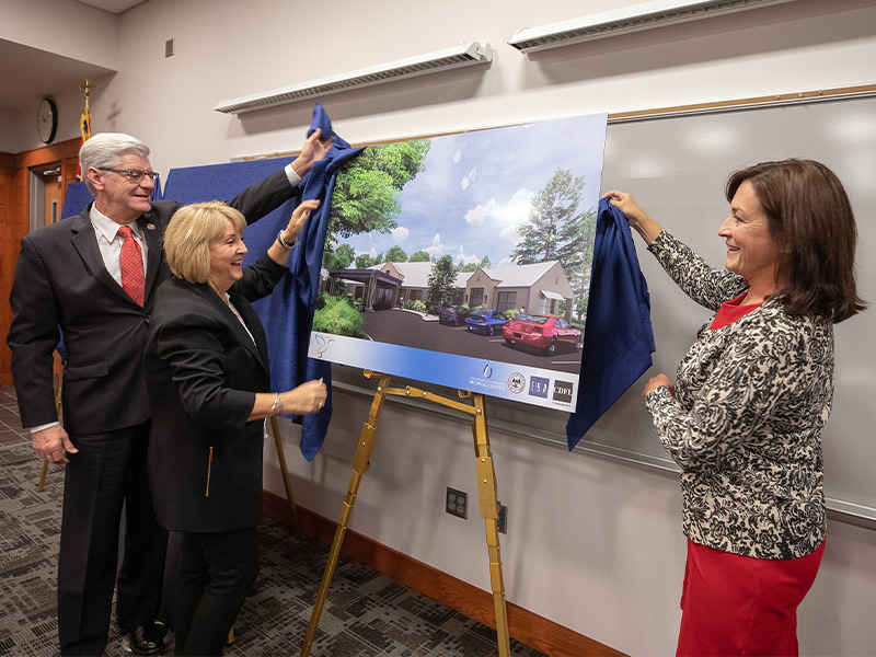 Gov. Phil Bryant looks on as wife Deborah Bryant and Dr. Mary Taylor, right, unveil a rendering of the state's first pediatric skilled nursing facility.