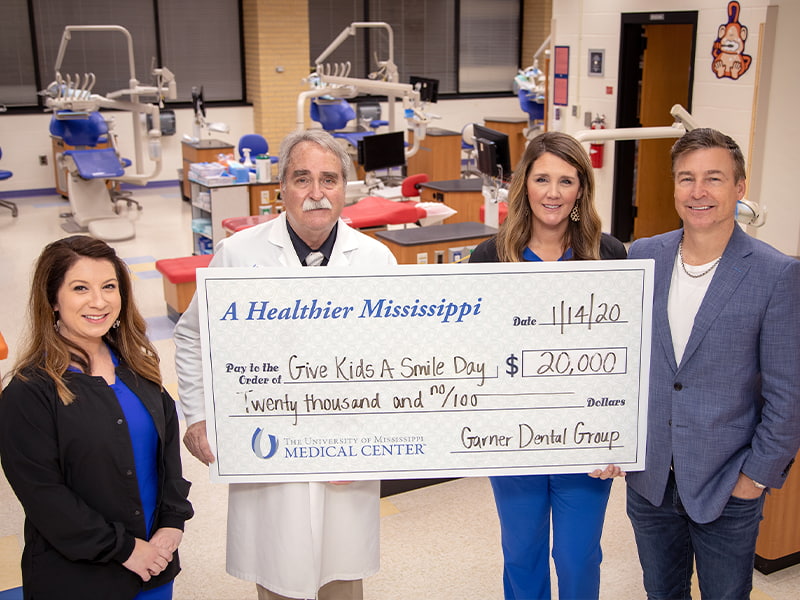 Dr. Lake Garner is committing $20,000 a year to sponsor the University of Mississippi School of Dentistry's annual event Give Kids a Smile. Pictured from left; Sharley Hamm, Chief Marketing Officer – Garner Dental Group; Dr. David Felton, Dean, School of Dentistry; Jessica Edwards, Marketing Assistant & Event Coordinator – Garner Dental Group; Garner, Chief Executive Officer – Garner Dental Group