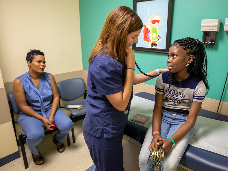 Sarah Elizabeth Elkin, nurse practitioner, checks Kali Mitchell's heartbeat as Mitchell's mother, Joneaset Mitchell, looks on.