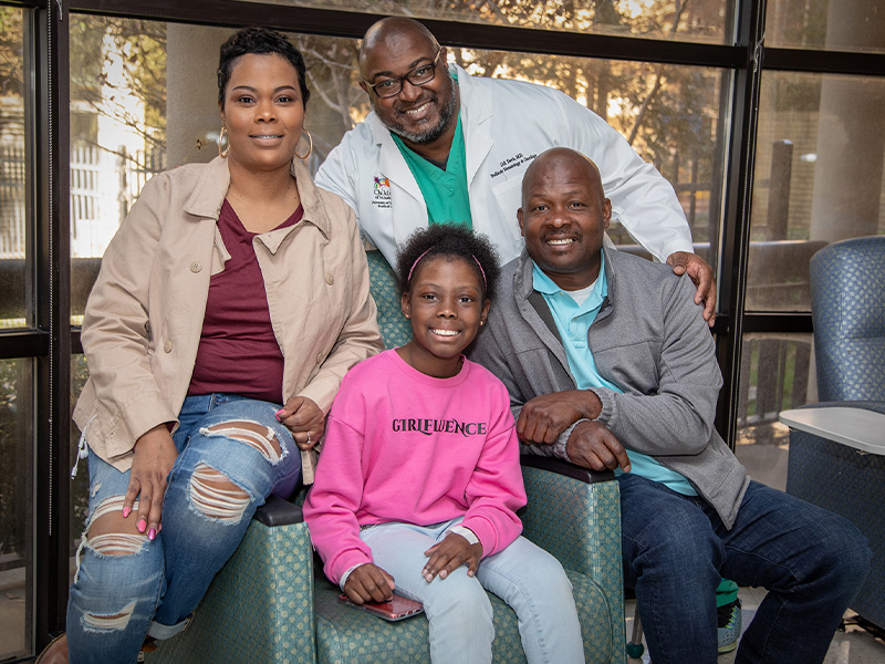 Kali Mitchell smiles along with her parents, Joneaset and Darold Mitchell, and hematologist/oncologist Dr. Dereck Davis.