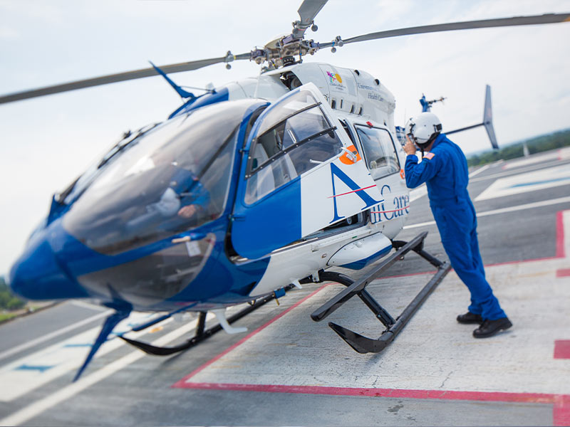 Man and helicopter on helipad.