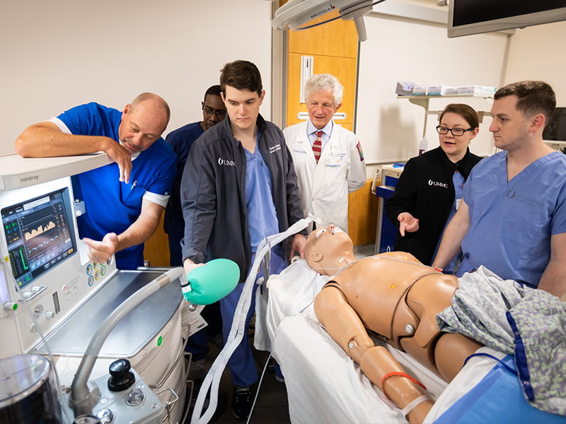 Casey Keith, left, Mindray sales representative, enlightens his audience about the features of the new anesthesia machine. From left are Patrick Parker, Simulation Center coordinator; medical student John Robison; Dr. William Hulett, associate professor of anesthesiology; and medical students Candise Johnson and Alexander Meyer.