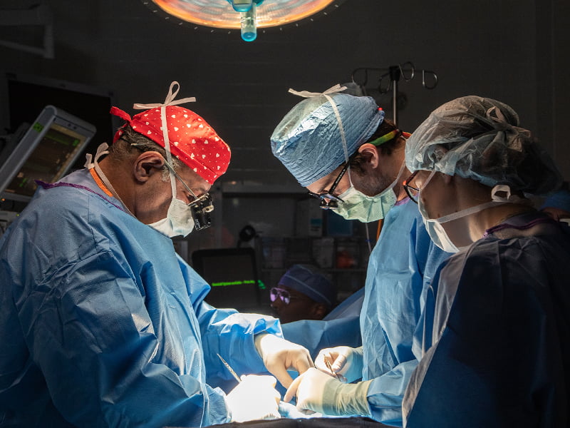 Three medical staff during surgical procedure.