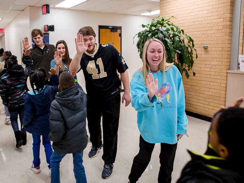 Dental students high five elementary students.