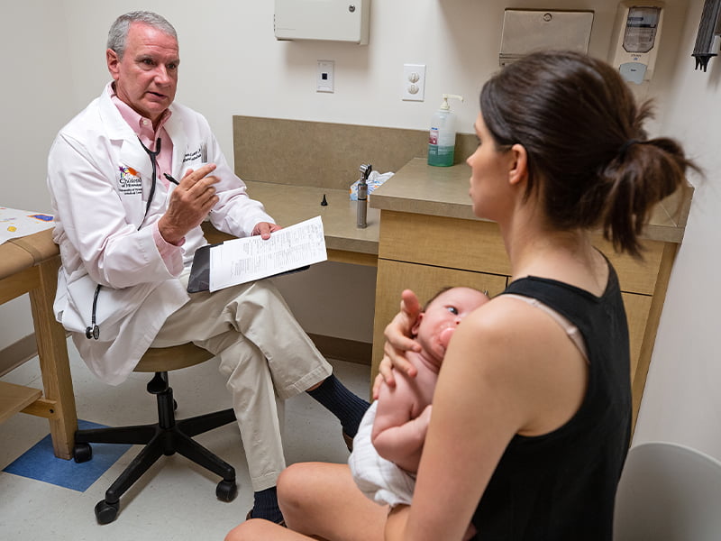 Doctor talks to mother holding baby.