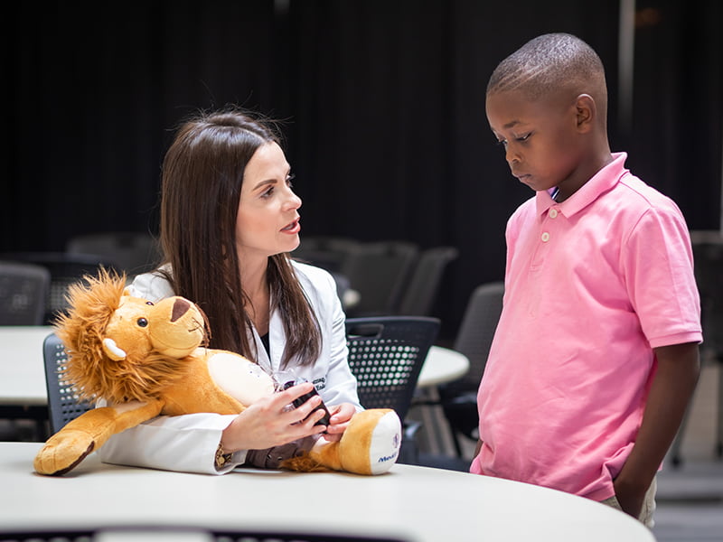 Dr. Katelyn Armstrong, a nurse practitioner in pediatric endocrinology, teaches Ahmir Brooks how to use an insulin pump.