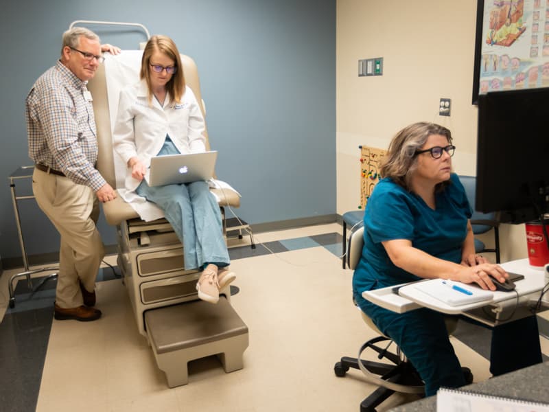 Dr. Robert Brodell, UMMC dermatology chair, joins Dr. Caitlyn Trotter Reed, center, dermatology house officer, and Tracy Breeden, nurse, to conduct a telehealth video conference with a patient.