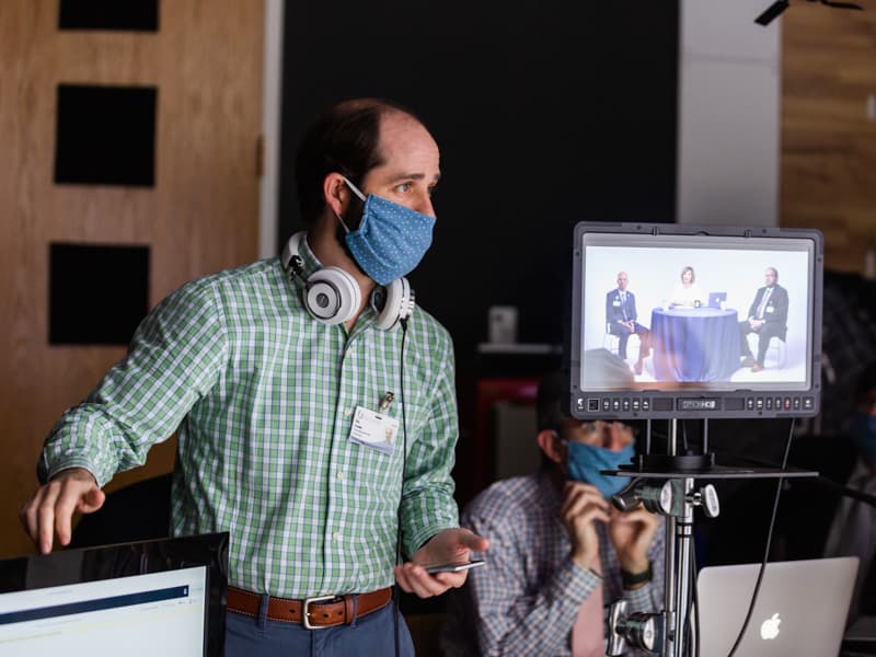 Win Graham wearing mask and standing by video equipment.