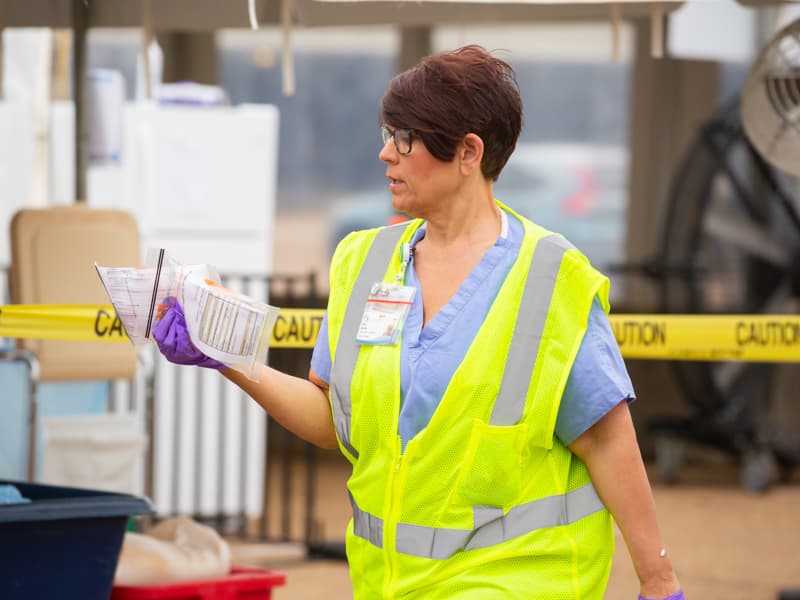 Tricia Opdyke, who oversees logistics at UMMC's Mississippi State Fairgrounds COVID-19 testing site, delivers equipment to a tent.