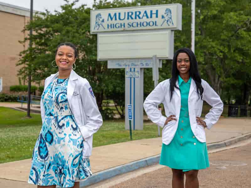 School of Pharmacy graduates Andrea Washington, left, and Brianca Fizer visit the place where their career goals began - Murrah High School.