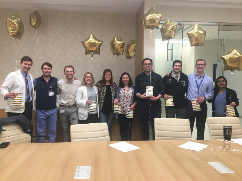 A group of previous Gold Humanism inductees collect balloons and bags for delivery to the newest group of initiates on Tap Day, March 5. They are, from left, Dr. Austin Puckett, Dr. Jackson Browning, Dr. Zack Watson, Dr. Erin Dyer, Dr. Melinda Talley, Dr. Emily McBride Youngblood, Dr. Graham Husband, Dr. Sean Himel, Dr. Blake Littlejohn, and Dr. Omama Ahmad. Many of the tappers were still students when the photo was taken, but have since graduated from the School of Medicine.