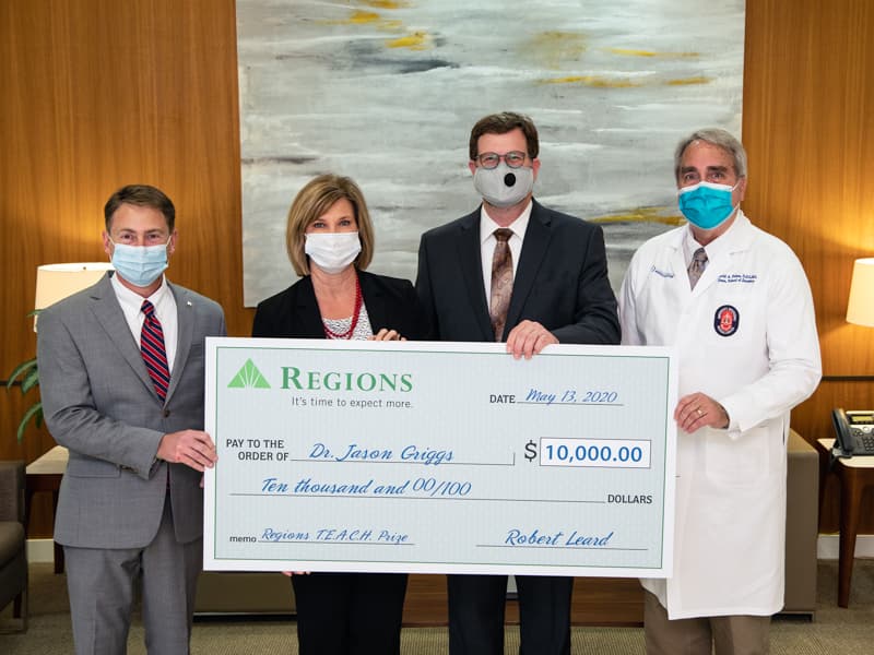Dr. Jason Griggs, second from right, receives a cash award while, from left, Robert Leard of Regions, Dr. LouAnn Woodward and Dr. David Felton look on during the Regions Bank TEACH Prize presentation.