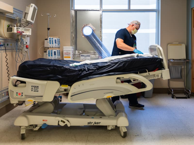 Mike Henrickson, a MICU registered nurse, prepares a room for the next patient.