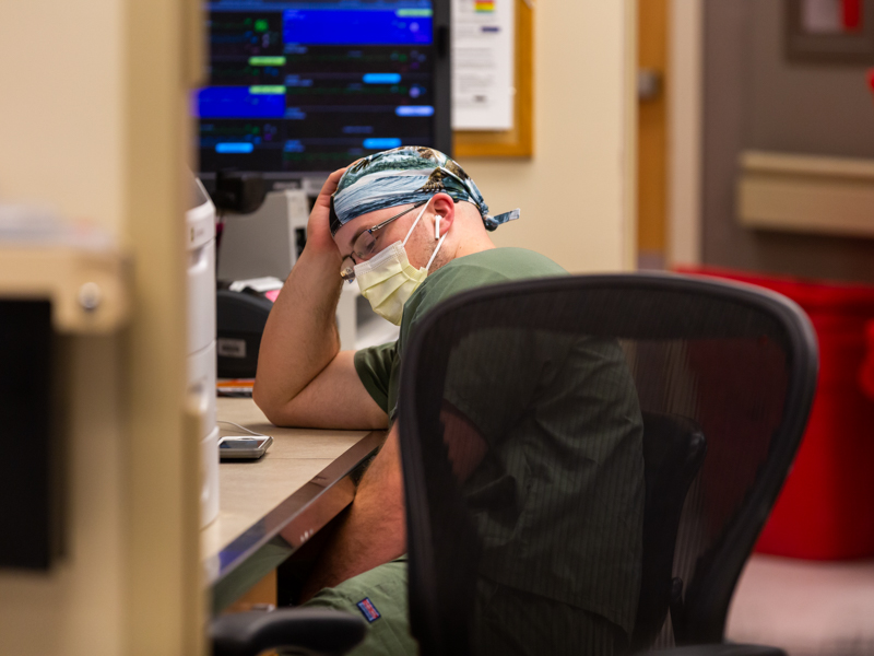 Registered nurse Kevin Marchant takes a moment to breathe in the MICU, where very ill COVID-19 patients receive care.