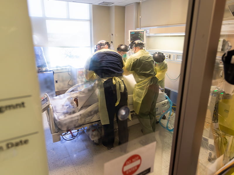 Four providers in the medical ICU team "prone" a COVID-19 patient with respiratory issues by lifting and swiftly flipping him from his back to his stomach to help him breathe.