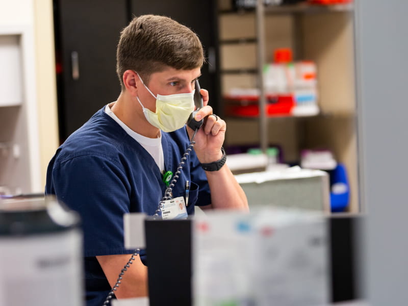 Man in scrubs on phone