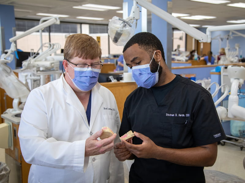 Dr. Mark Livingston, left, chair of the Department of Advanced General Dentistry, consults with Dr. Stedman Hurdle, dental resident.