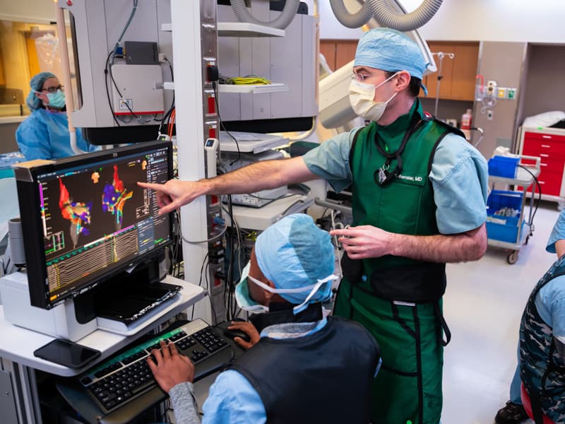 At University Heart, Dr. James "Mike" Bensler, center, with, from left, Jennifer Haseloff, R.N.; Quentin Greathree, a Jackson-based member of Abbott Laboratories' support staff; Andrew Fisher, a cardiovascular interventional technologist; and Evan Byas, R.N., prepare for a procedure on one of the three dozen or so patients Bensler and his colleague Dr. James Hamilton see each day.