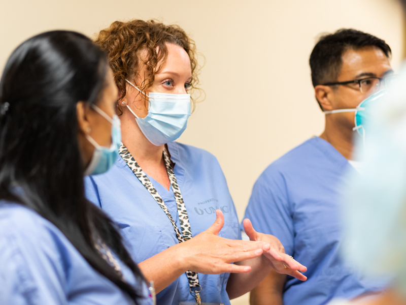 Leslie Hood, nurse educator on the Labor and Delivery floor, briefs other caregivers on the status of COVID-19 patients during rounds.