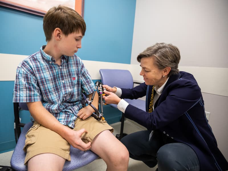 Hunter Lindsay watches as Leitch adjusts his external fixator in September 2019.