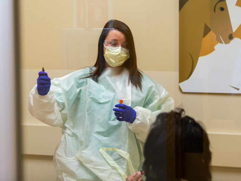 Registered nurse Shelby Grey administers a COVID-19 test to an employee. Testing is performed in the Pediatric Acute Respiratory Clinic.