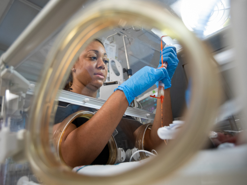 Javita Fitzgerald, an RN in Children's of Mississippi's neonatal intensive care unit, prepares breast milk to be fed to a patient via feeding tube.