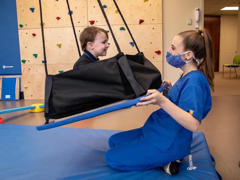 Mary Lowry Vollema, occupational therapist, works with Justin Youngblood of Pearl, an ASD patient, at the Center for Advancement of Youth.