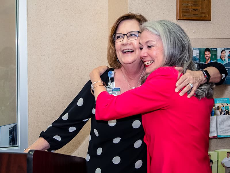 Harris shares a hug with Terri Gillespie, chief nursing executive and clinical services officer, at the School of Nursing retirement reception.