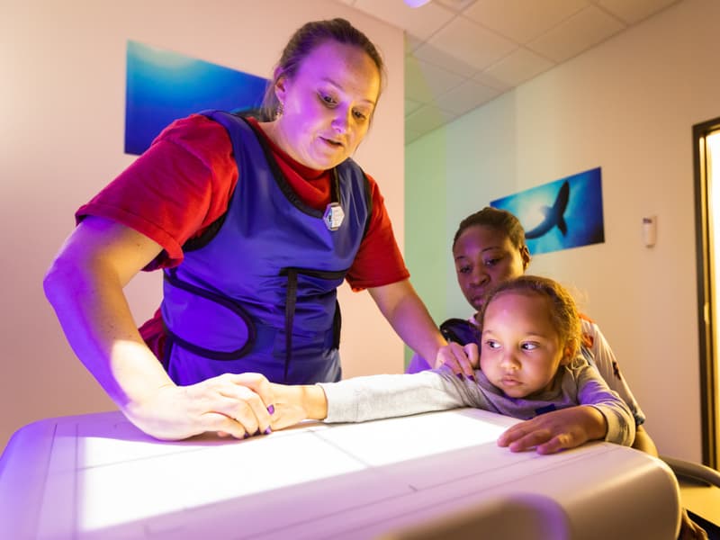 Radiology technician Beth Lee gets Xavier Strahan ready for an X-ray in February at the Children's of Mississippi Biloxi specialty clinic.