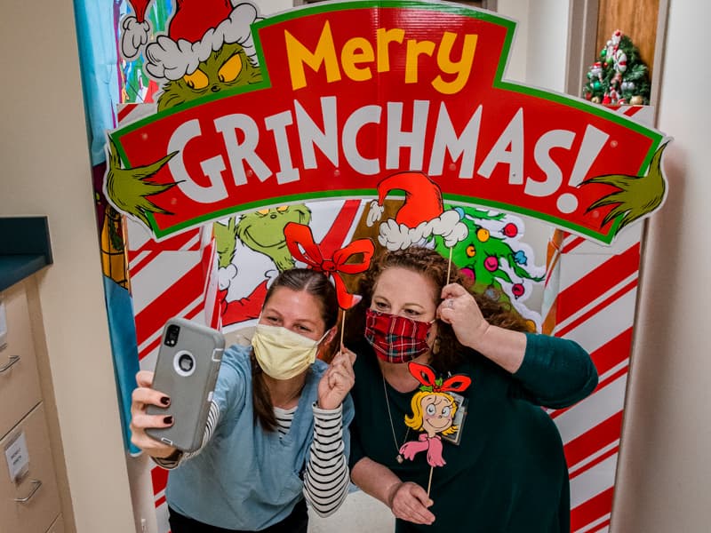 Kelsey Tadlock, left takes a selfie with her pediatric nurse practitioner instructor Michelle Goreth at her Merry Grinchmas decorations in the School of Nursing.