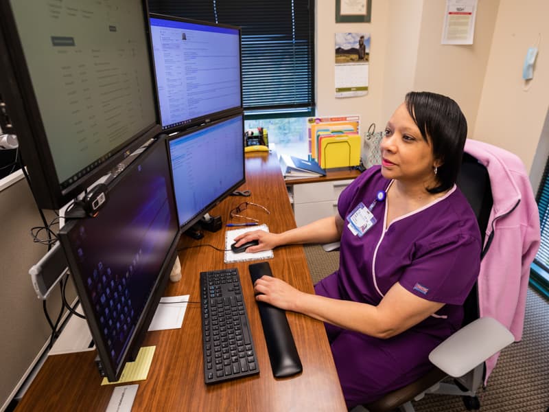 Shirley Stasher, a Center for Telehealth nurse, reviews remote medical data for Martha O'Cain of Canton.