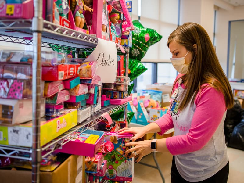 Child life specialist Cara Williams sorts through the many dolls donated for children's hospital patients in this 2020 file photo.