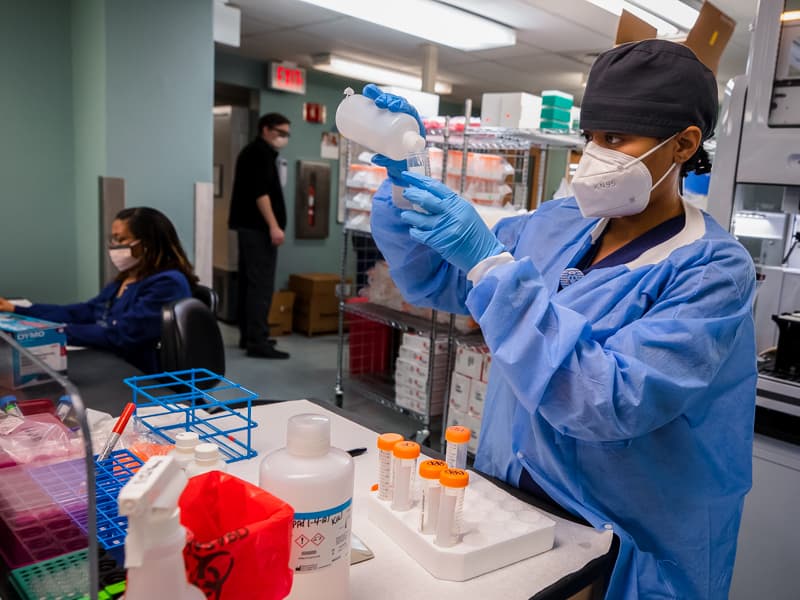 Registered medical technologist Luressie Jones prepares COVID-19 samples for placement in the new Biomek i7 automated robot.