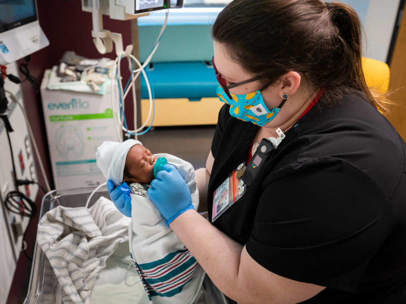 Registered nurse Lauren Cox cares for Harlem Smith in his neonatal intensive care room in the Kathy and Joe Sanderson Tower at Children's of Mississippi.