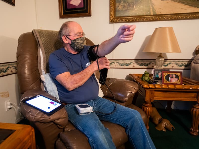 Stephen Dawkins of Vicksburg puts on his blood pressure cuff for a fresh reading that will be transmitted to UMMC's Center for Telehealth using a Bluetooth-enabled tablet.