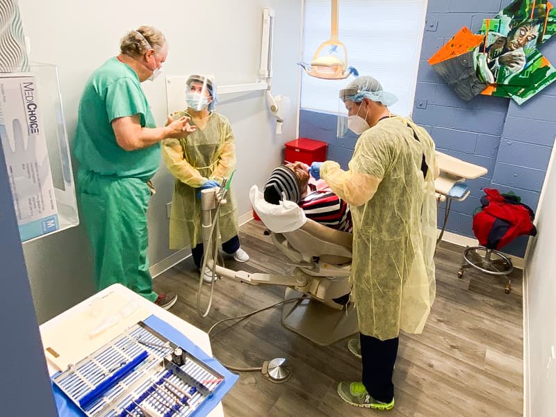 Providing dental care for Vondregus Bailey, a Jackson Free Clinic patient, are, from left, Dr. George May, associate clinical professor of oral and maxillofacial surgery, Kara Cook, dental student, and Hayden Coffey, dental student.