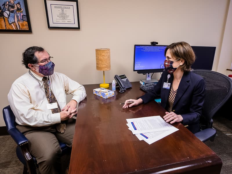 Dr. Roy Duhe, left, meets with Dr. Sara Gleason, professor of psychiatry and human behavior, after becoming one in eight COVID-19 survivors last spring who, within six months of testing positive, were diagnosed with a mental disorder for the first time.