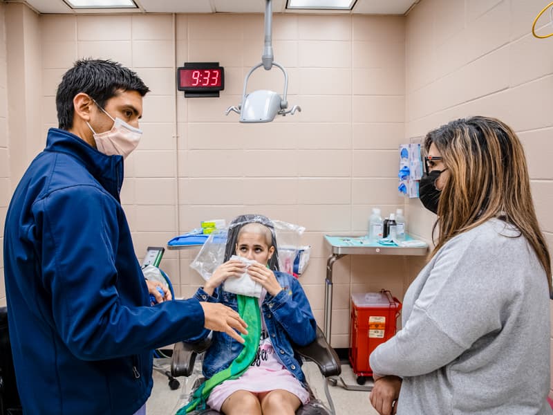 Dr. Ignacio Velasco-Martinez chats with Maria Pagan about daughter Almarie Maldonado Pagan's recovery from surgery to remove cancer on her jaw and reconstruct her jaw bone with Almarie's own fibula.