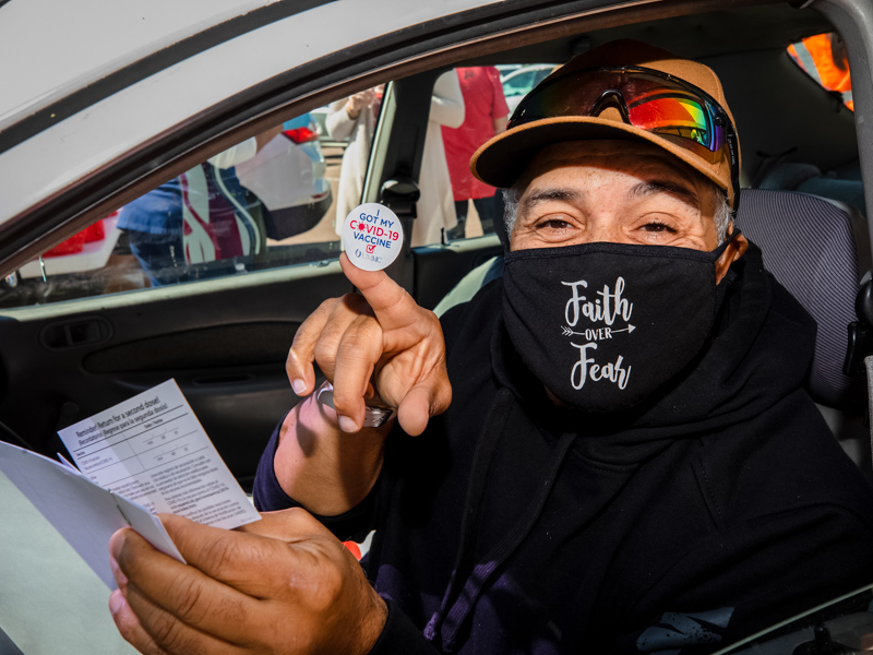 Jackson resident Earl Boone shows off a sticker proclaiming he's been vaccinated for COVID-19 seconds after receiving the shot April 21 at UMMC's EversCare.