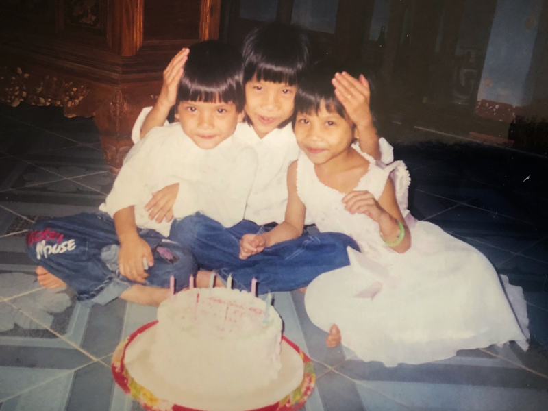 Phuong Le, right, and her brother Kha Le, left, cuddle with their sister Leana Le on Leana's birthday, as shown in this photo, circa 2005. (Photo courtesy of Phuong Le)
