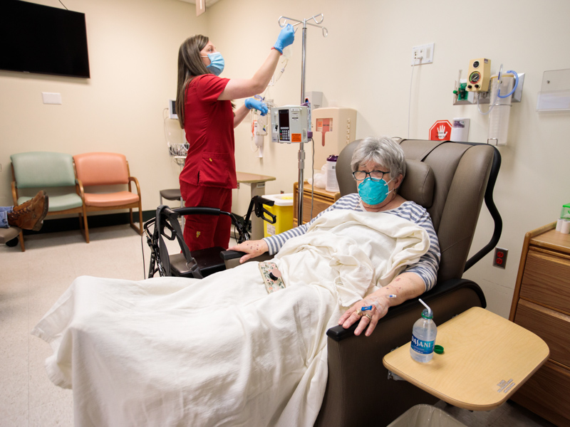 Jessica Greer, left, a perioperatiove nurse at UMMC Grenada, checks IV equipment to be used by Geraldine Hammons of Gore Springs, who's receiving an immunotherapy drug infusion to fight her cancer.