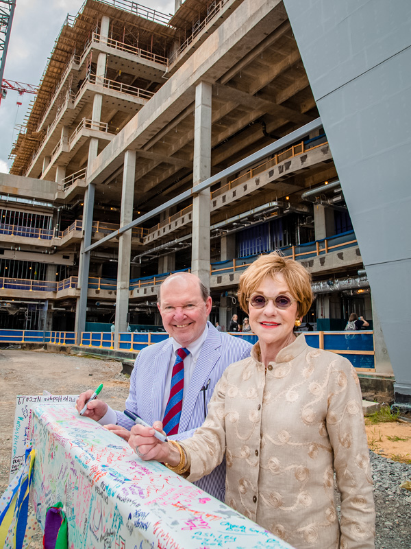 Joe and Kathy Sanderson are shown signing the beam that was placed at the top of the seven-story Sanderson Tower in 2019.