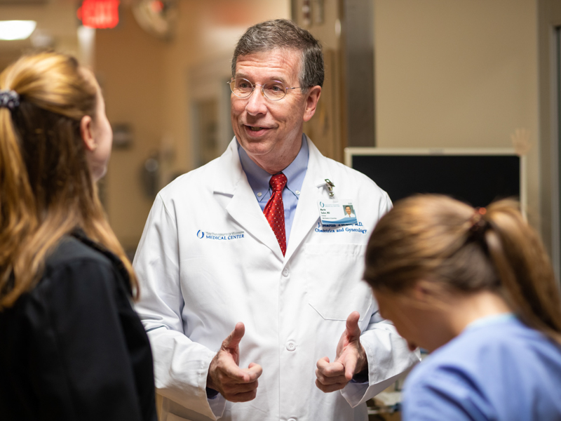 Dr. J. Martin Tucker talks with medical students Ruth Fowler, left, and Tori Wilson in this file photo from early 2020.
