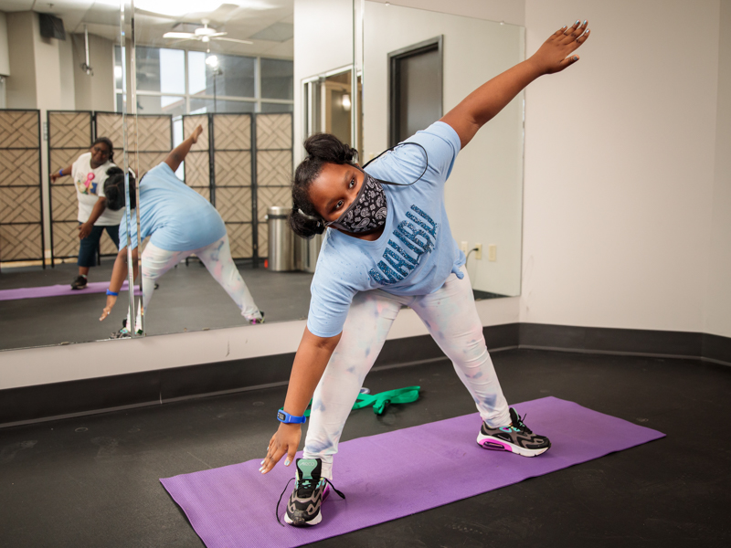 Iron Kid Mackenzie Dixon exercises with Danayia Cox, shown in the reflection, during an Iron Kids class.