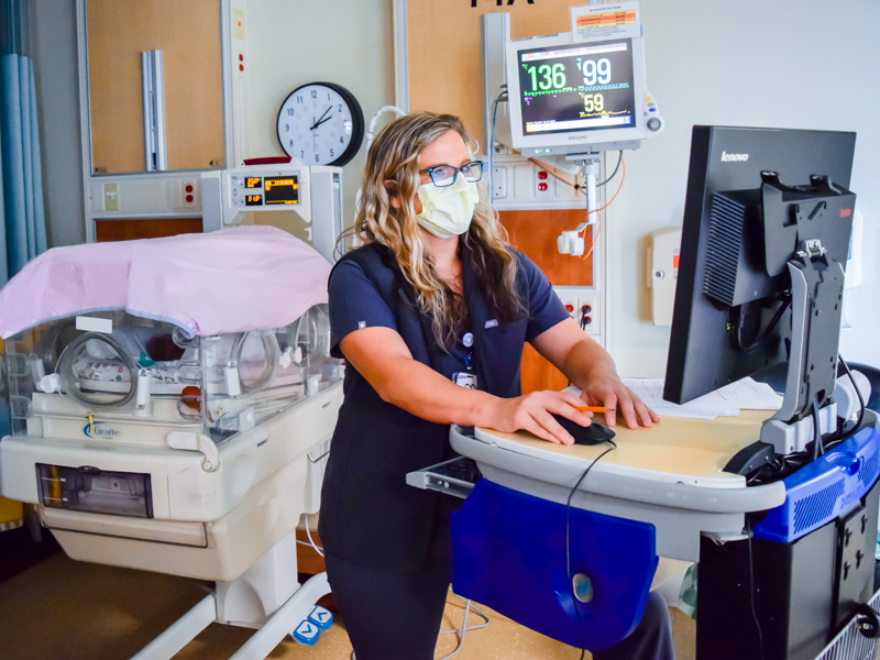 Anna Noel, a UMMC neonatal nurse practitioner, checks a baby's record in the NICU at North Mississippi Medical Center.