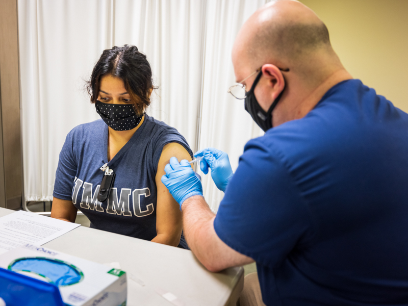 Jaspreet Kaur, a registered nurse on 4 Wiser, receives her vaccination Thursday from licensed practical nurse Robert Roka.