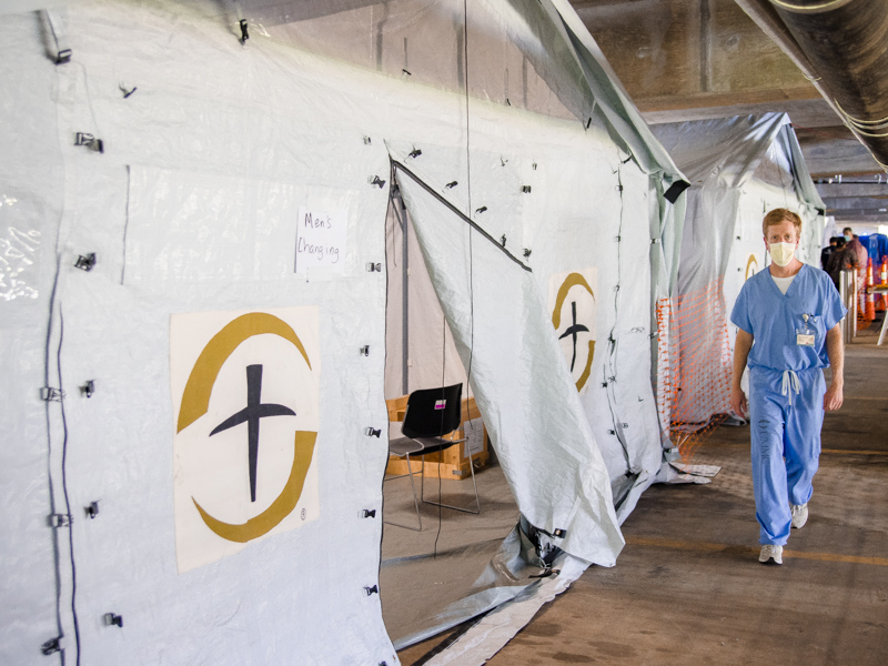 Dr. Andy Wilhelm, division chief of pulmonary and critical care medicine, walks past a row of Samaritan's Purse field hospital tents.