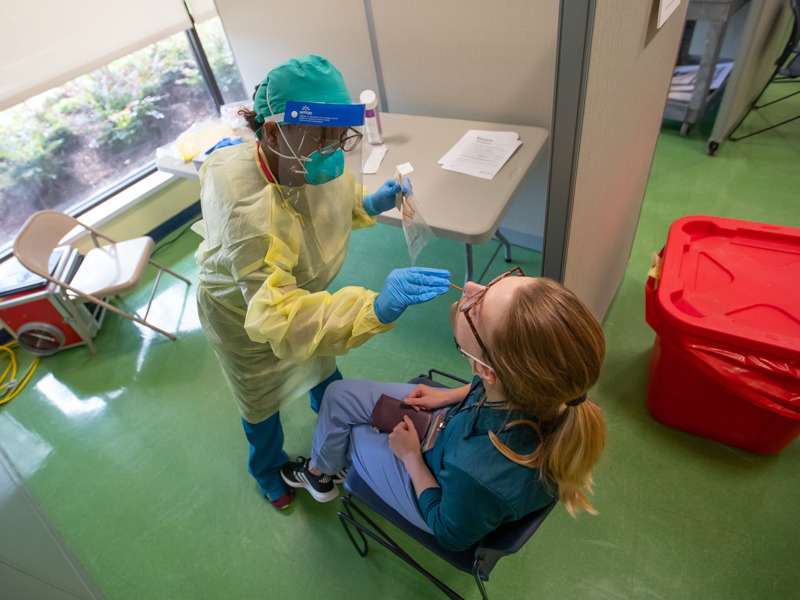 Certified medical assistant Banca Wallace administers a COVID-19 test to employee Kelsie Huffman.