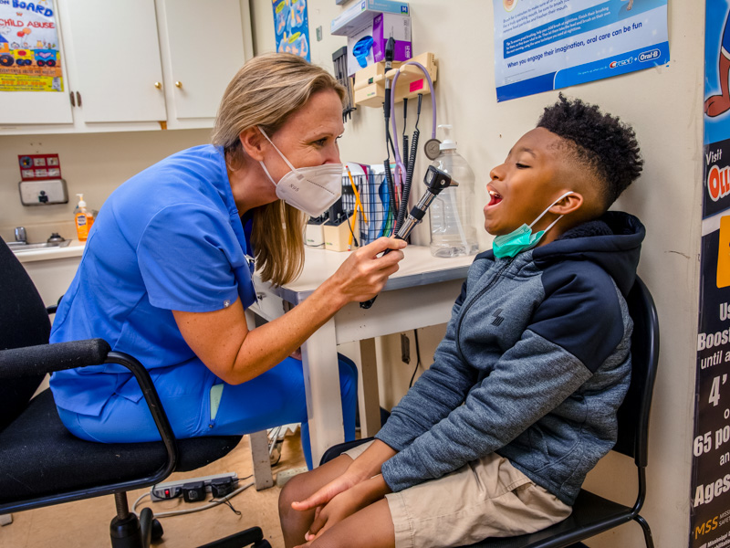 Nurse practitioner Valerie Morris takes a look at the throat of Darell Anthony, a fourth-grader at Johnson Elementary.