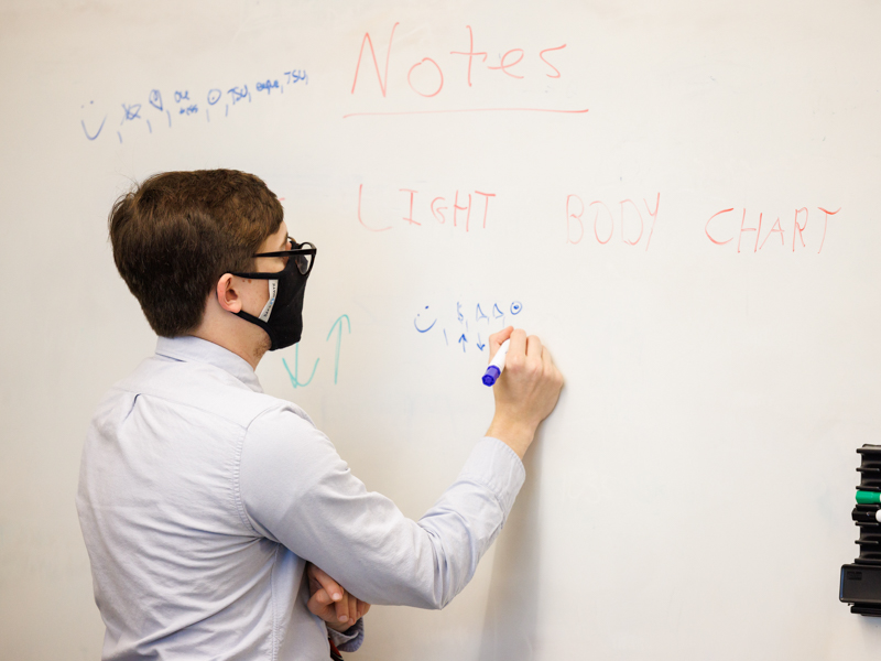 Medical student Logan Ryals takes notes as the team works to decipher the puzzles of the UMMC escape room.